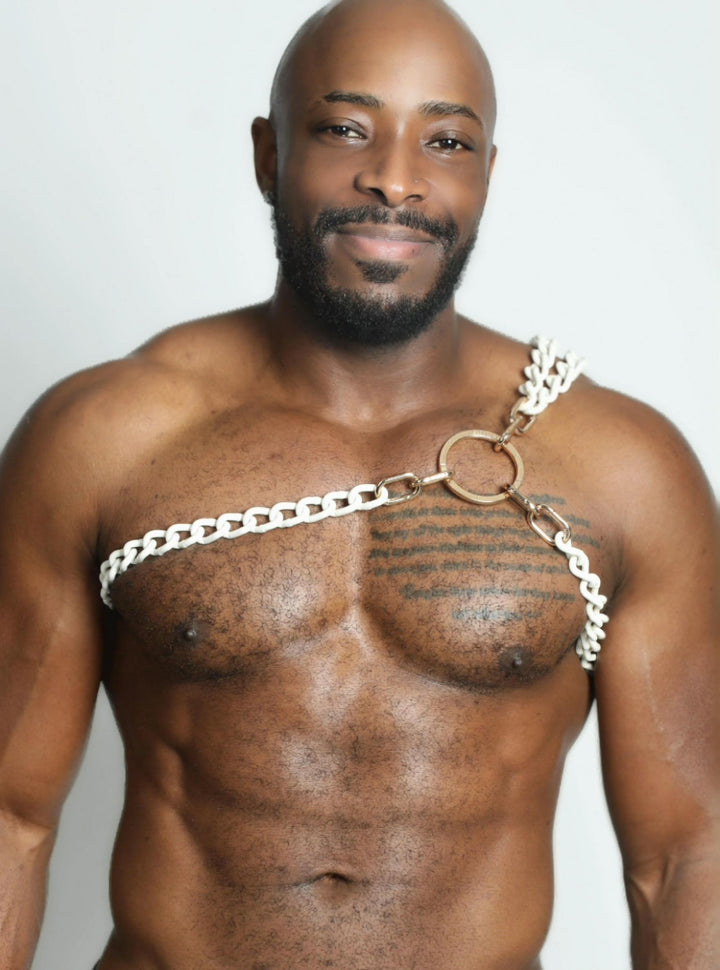 A man wearing a stainless steel double chain gladiator harness over his shoulder.